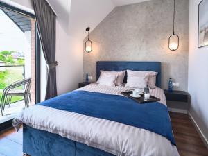 een slaapkamer met een groot bed met een blauw hoofdeinde bij Apartamenty Marinera in Łeba