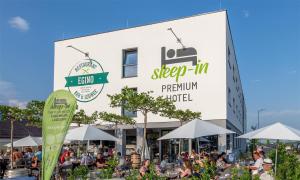 un grupo de personas sentadas frente a un edificio en Sleep in Premium Hotel Eggenburg, en Eggenburg