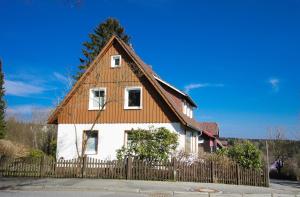 ein Haus mit einem Holzdach und einem Zaun in der Unterkunft Ferienhaus Blocksberg in Braunlage