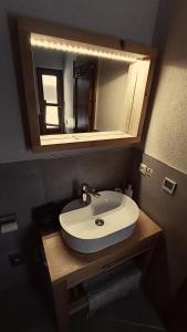 W łazience znajduje się biała umywalka i lustro. w obiekcie DREVENÁ CHALÚPKA Slovenský raj HRABUŠICE w mieście Hrabušice