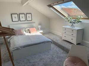 a attic bedroom with a bed and a window at The Old Foundry Wallingford Apartment & Parking in Wallingford
