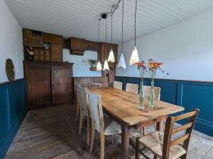 uma sala de jantar com uma mesa de madeira e cadeiras em Relax in the Haute Vienne. em Séreilhac