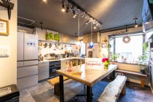 cocina grande con mesa de madera y barra en Hotel Tokyo Hub, en Tokio