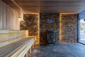 um quarto com uma parede de pedra e um banco de madeira em Hotel Podgorie Spa em Bukovel