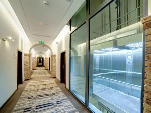 un couloir d'un bâtiment avec des fenêtres en verre dans l'établissement Hotel Loft 1898, à Suwałki