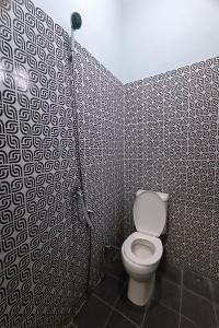 een badkamer met een wit toilet in een kamer bij OYO 92833 Penginapan Syariah in Pekanbaru