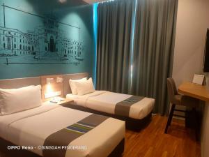 Postel nebo postele na pokoji v ubytování Singgah Pengerang Hotel