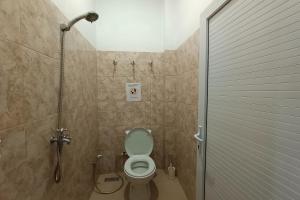 een badkamer met een douche en een toilet in een stal bij OYO 92833 Penginapan Syariah in Pekanbaru