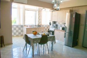 eine Küche mit einem Tisch mit Stühlen und einem Kühlschrank in der Unterkunft Eva's Residence, Family Apartment in Chania