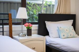 1 dormitorio con 2 camas y mesa con lámpara en Belmore Affordable 2 Br Granny Flat, en Sídney