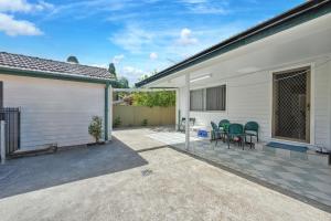a patio with a table and chairs next to a house at Belmore Affordable 2 Br Granny Flat in Sydney