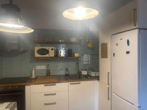 uma cozinha com um frigorífico branco e um micro-ondas em FORNELLS 003 em Es Mercadal
