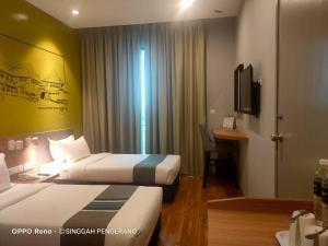 Postel nebo postele na pokoji v ubytování Singgah Pengerang Hotel