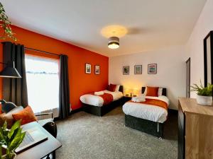 - 2 lits dans une chambre aux murs orange dans l'établissement Oxford House - Great for Contractors or Family Holidays, à Cleethorpes