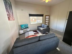 un soggiorno con divano blu e TV di 1 Bedroom Apartment near Graftons Waterfront a Grafton
