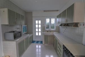 a kitchen with green cabinets and a microwave at Turquoise in Blue Bay