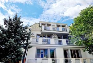 - un immeuble d'appartements blanc avec balcon et arbres dans l'établissement Atlantic Boutique, à Târgu-Mureş