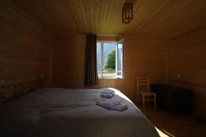 a bedroom with a bed with a window in it at Cottages SHIKHRA - კოტეჯები შიხრა in Mazeri