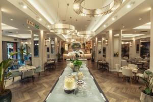 a lobby of a restaurant with tables and chairs at African Pride Melrose Arch, Autograph Collection in Johannesburg