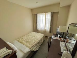 a hotel room with a bed and a desk at Ichihara Marine Hotel in Ichihara