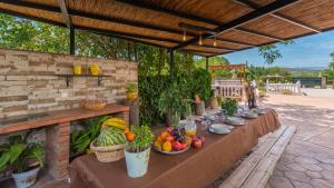 una mesa larga con frutas y verduras. en Casa Rural Marquez Ronda by Ruralidays en Ronda