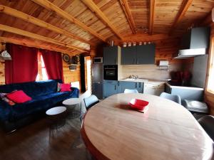 a living room with a wooden table and a kitchen at Marne LAC DU DER JOLI CHALET AU CHARME DU DER in Châtillon-sur-Broué