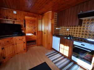 cocina grande con armarios de madera y TV en I de Mattu IDM1, en Blatten bei Naters