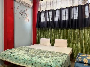 a bedroom with a bed with a green curtain at Indra Paying Guest House in Varanasi