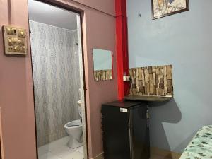 a bathroom with a toilet and a black refrigerator at Indra Paying Guest House in Varanasi