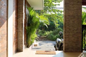 水明漾‎的住宿－Gelatik Bed And Breakfast，棕榈树房子的走廊