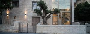 a tree in a planter in front of a building at Hapalmah One, Jerusalem, Dira 4 in Jerusalem