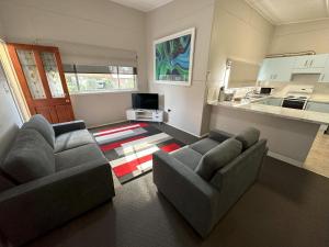 a living room with two couches and a kitchen at 2 Bedroom Apartment near Graftons Waterfront in Grafton