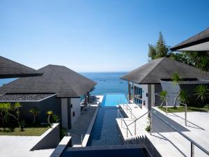 a villa with a swimming pool and the ocean at Suluban Cliff Bali Villa in Uluwatu