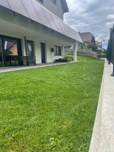 a green yard next to a building at Ferienwohnung Siri Zentrum mit Garten in Sankt Michael im Lungau