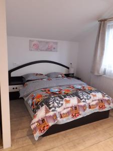 a bedroom with a bed with a comforter on it at Cazare REGIM HÔTELIER ZĂRNEŞTI in Zărneşti