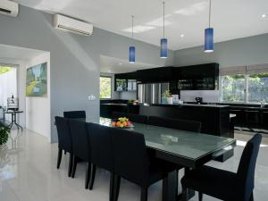 uma cozinha e sala de jantar com uma mesa de vidro e cadeiras em Suluban Cliff Bali Villa em Uluwatu