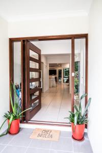 una puerta giratoria que conduce a una sala de estar con plantas en Chez Brolga, en Port Douglas