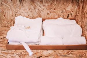a suitcase filled with white sheets and folded towels at ลีฟ เลค กาญจน์ รีสอร์ท in Ban Hin Hak