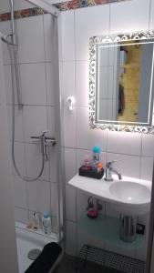 ein weißes Badezimmer mit einem Waschbecken und einem Spiegel in der Unterkunft Rob´s Place in Langenfeld