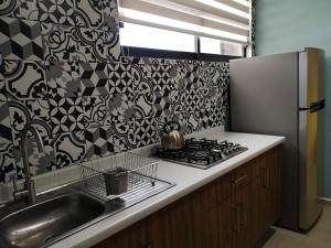 a kitchen with a sink and a refrigerator at Departamento Moderno en Centro de Zacatecas in Zacatecas