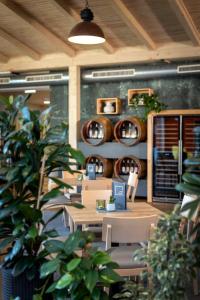 ein Restaurant mit Tischen, Stühlen und Weinfässern in der Unterkunft JUFA Hotel Deutschlandsberg in Deutschlandsberg