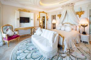 een slaapkamer met een bed, een bank en een tv bij Bilgah Beach Hotel in Baku