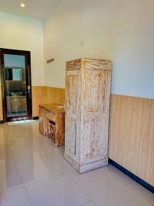 a large wooden cabinet in a room with a door at Lemon Guest House in Canggu