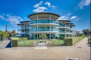 a large building with a fence in front of it at Gallery 10 with views, pool and tennis court in Victor Harbor