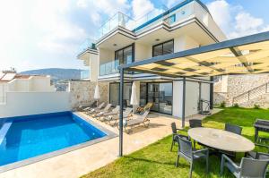 a villa with a swimming pool and a table and chairs at Eco Villa ECE in Kalkan