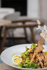 a plate of food with an egg and a salad at African Pride Melrose Arch, Autograph Collection in Johannesburg