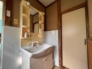 La salle de bains est pourvue d'un lavabo et d'un miroir. dans l'établissement Ryokan Sanki, à Kyoto