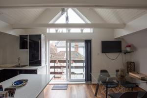 a kitchen and dining room with a glass table at The Penthouse Canterbury - Cathedral View in Canterbury