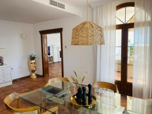 a dining room with a glass table and a chandelier at Sea view Villa La Alcaidesa in La Alcaidesa