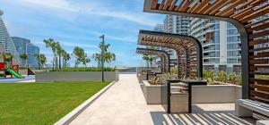 a park with benches and grass and buildings at Ultra Luxury Wasl 1 Residences Zabeel Park in Dubai